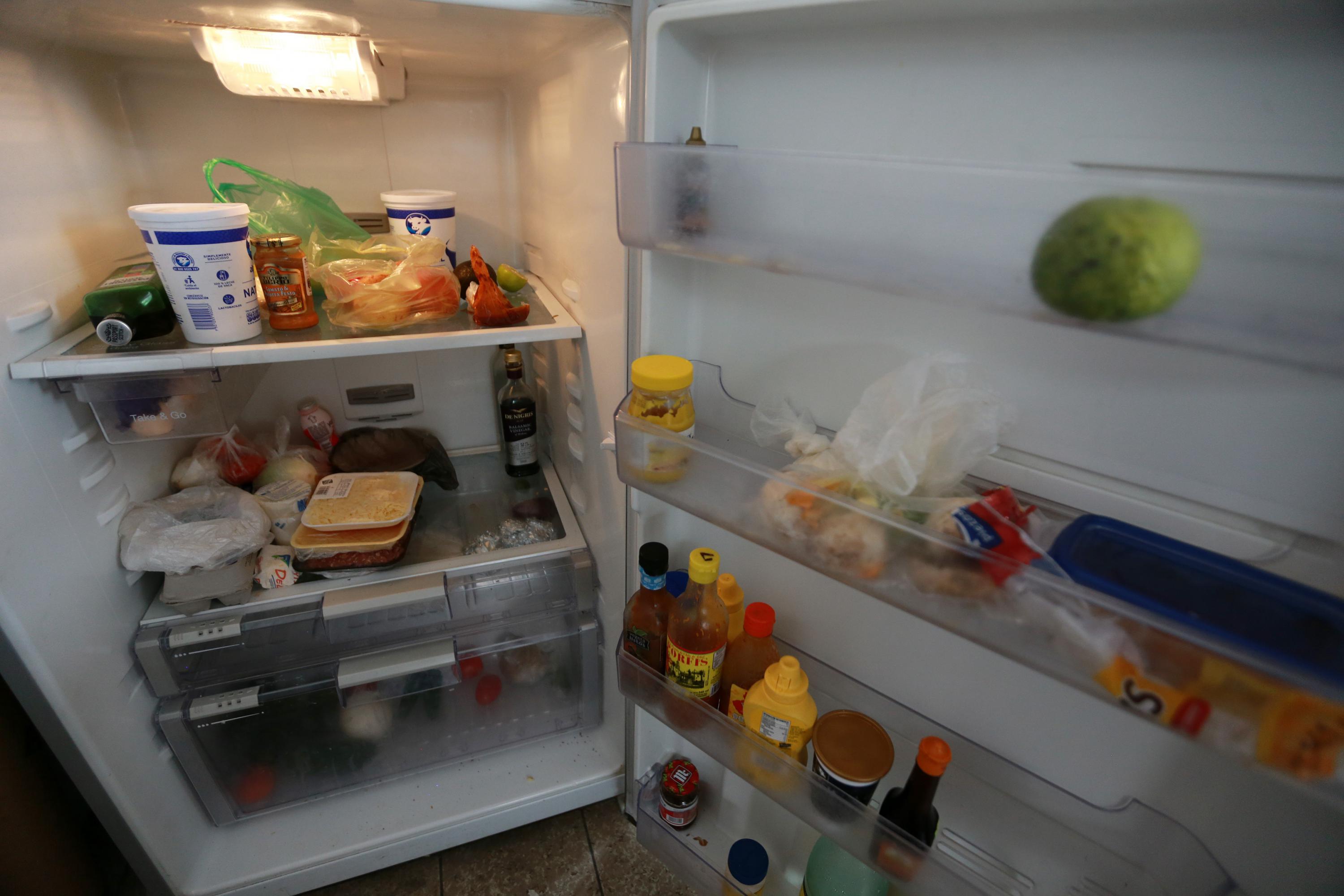 Refrigerador domestico con la puerta abierta con alimentos 