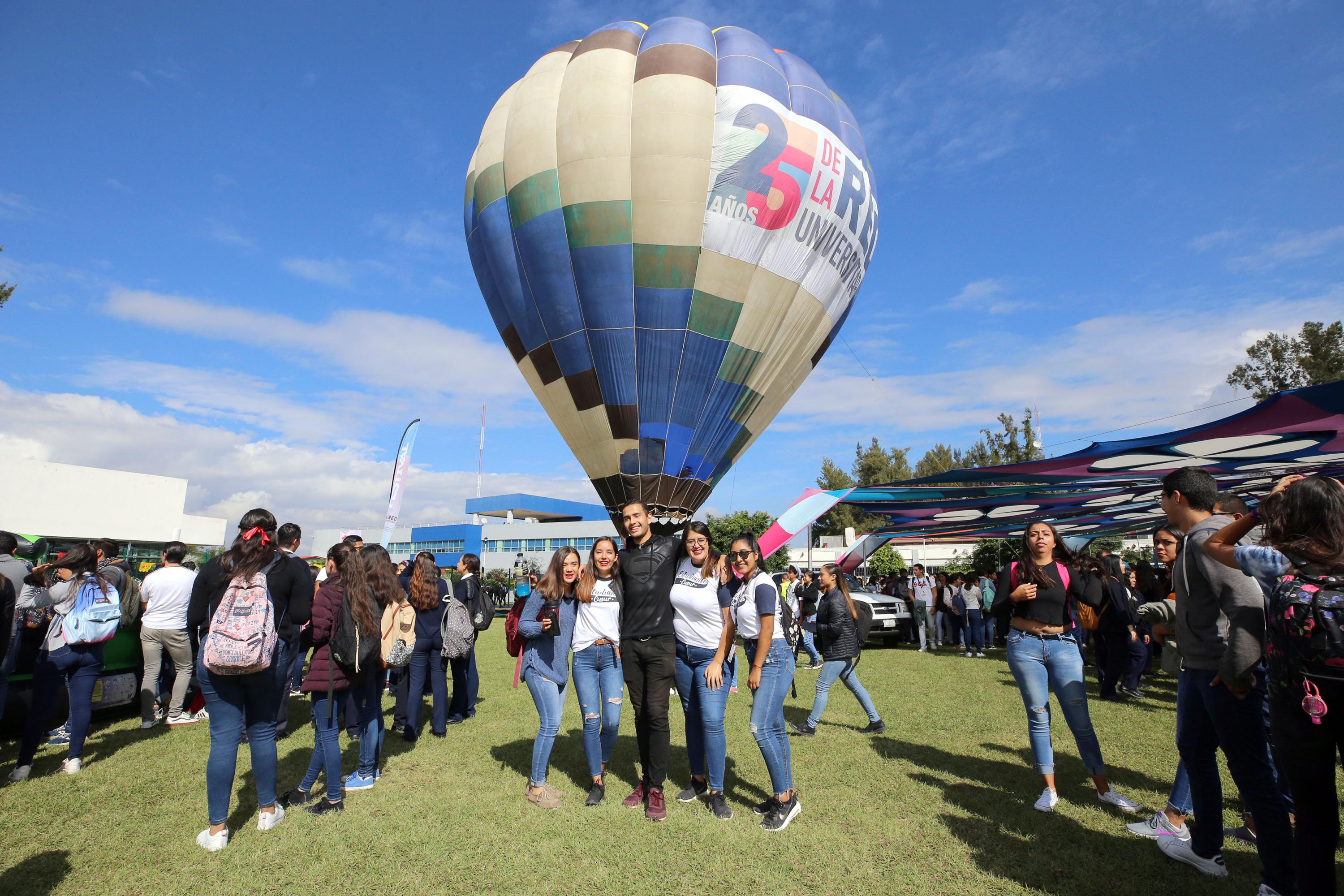 Estudiantes se toman la foto con el globo aerostático en el Festival Regional de CUSur en el marco de lo 25 años de la Red